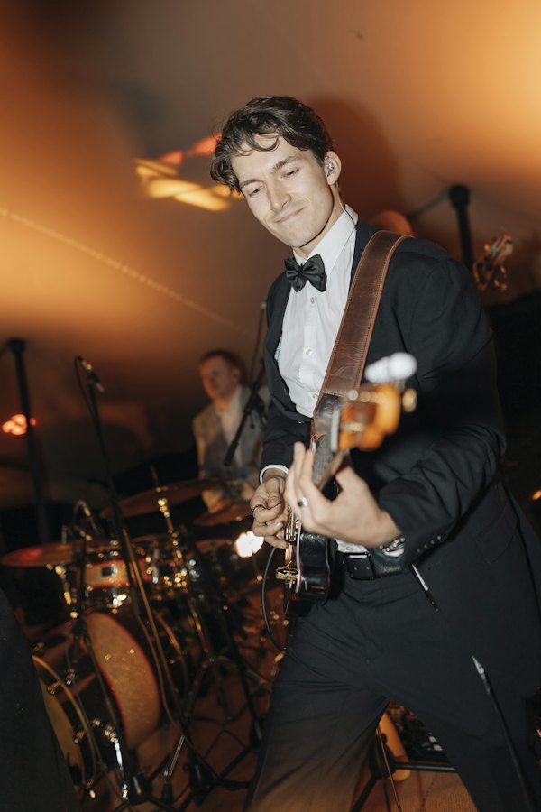 Musiker im Smoking spielt Gitarre