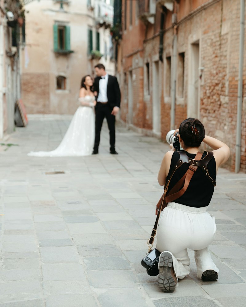 Fotografin fotografiert ein Brautpaar in einer Gasse